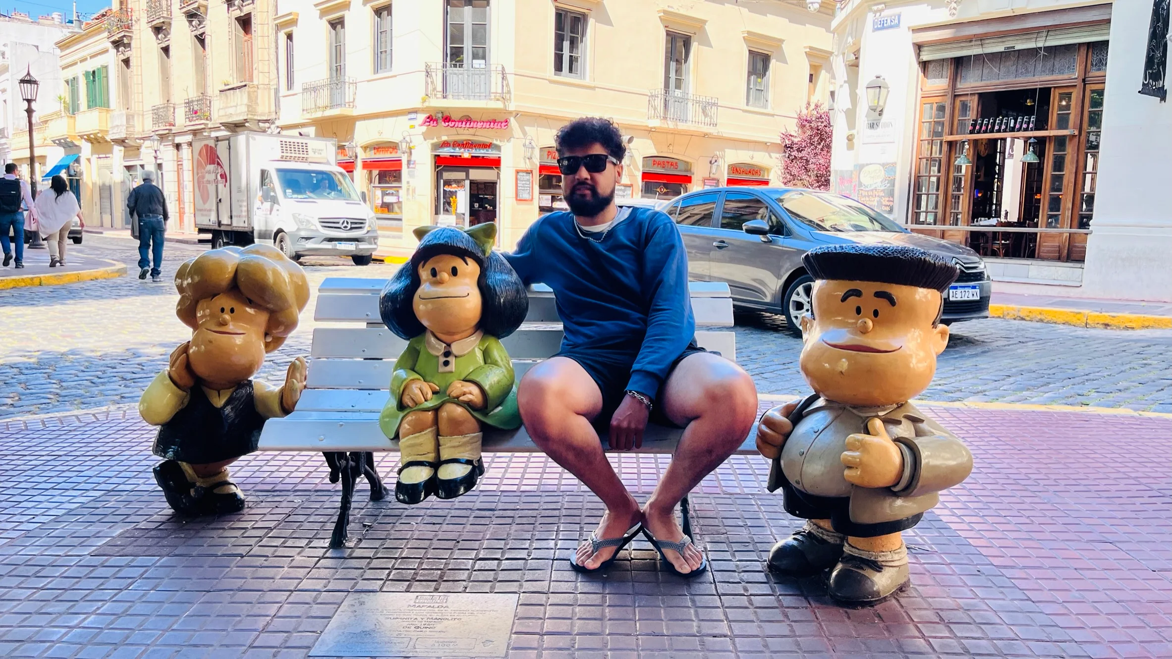 Turistas a tirar fotos com a estátua da Mafalda sentada num banco em San Telmo.